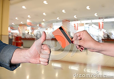 Woman holding credit card, man gesturing thumb up