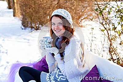 Woman holding a cup of tea in hand outdoors
