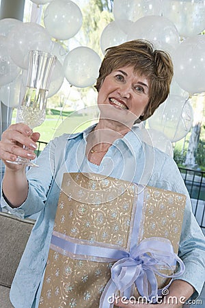 Woman Holding Gift And Champagne Flute At Party