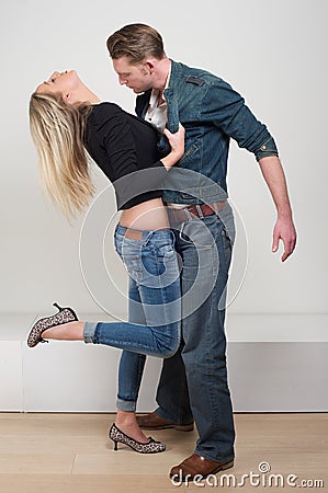 Woman holding jacket of attractive male model in passionate pose