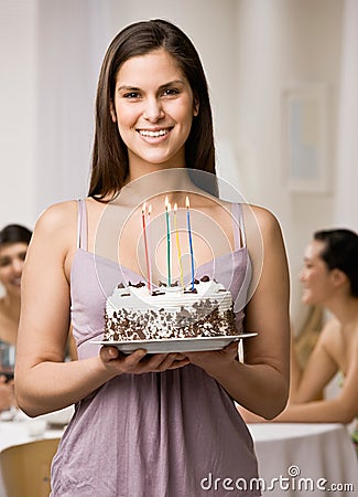 Woman holding lighted birthday cake