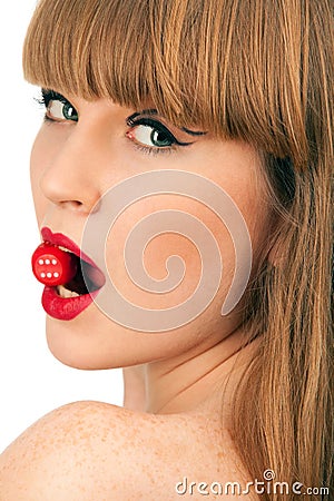 Woman holding in mouth a red dice