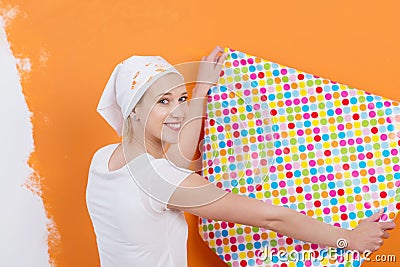 Woman Holding Wallpaper Against Orange Colored Wall