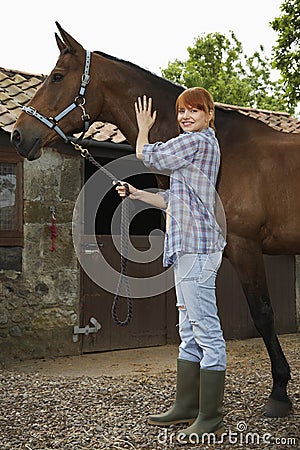 Woman With Horse Outside Stable