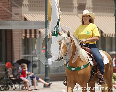 Woman on horseback for 4H in a parade in small town America