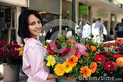 Woman with huge bouquet of flowers outdoors