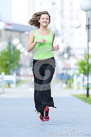 Woman jogging in city street park.