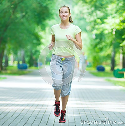 Woman jogging in city street park.