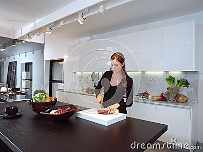 Woman in kitchen cutting ingredients