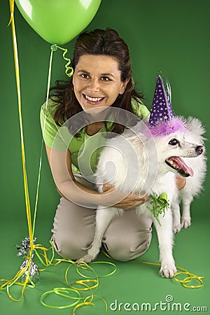 Woman kneeling with white dog.