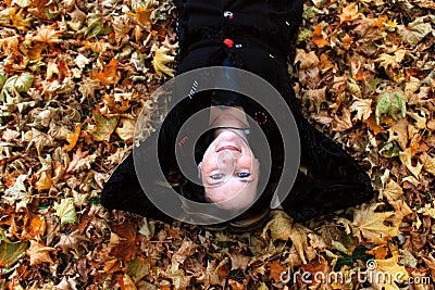 Woman laying in autumn leaves