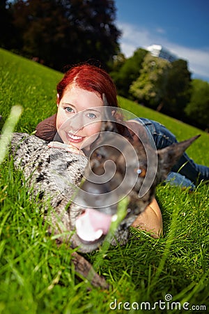 Woman laying with dog in park