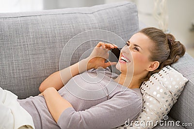 Woman laying on sofa and talking mobile phone