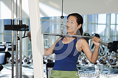 Woman Lifting Weights On A Lat Pull Machine