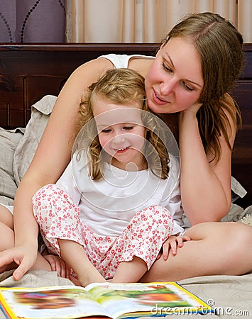 Woman and little girl read a book