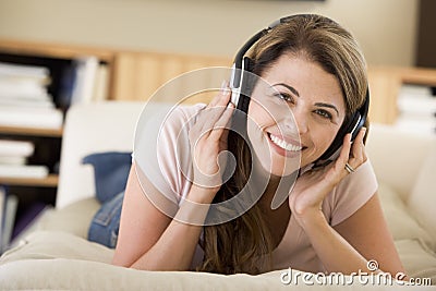 Woman in living room listening to headphones