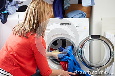 Woman Loading Clothes Into Washing Machine