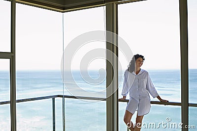 Woman Looking Away While Leaning On Railing In Balcony