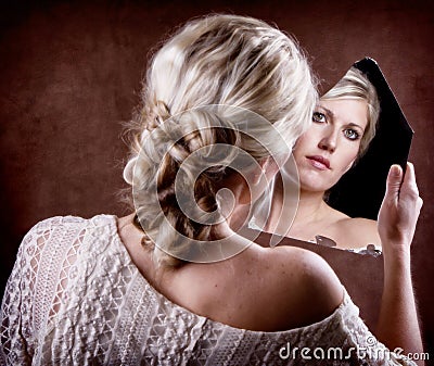 Woman looking into a broken mirror