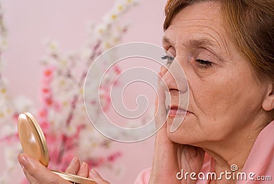 Woman looking at her face in the mirror