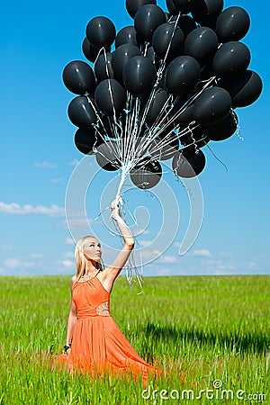 Woman looking up at the black balloons