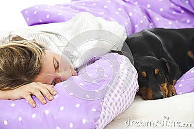 Woman lying in bed with dog