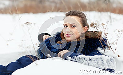 Woman lying in coat on snow