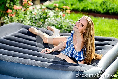 Woman lying on the mattress in the garden