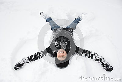 Woman making snow angel.