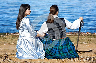 Woman and man in scottish costume near the sea