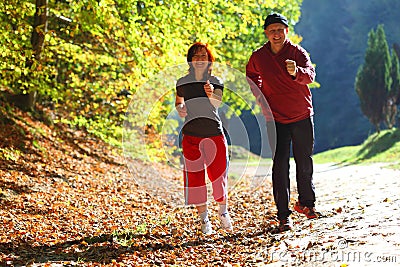 Woman and man walking cross country trail in autumn forest