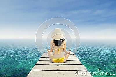 Woman meditating at serene beach