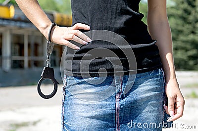 Woman in mini skirt holding handcuffs.