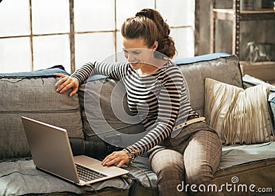 Woman with modern dslr photo camera using laptop