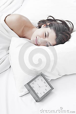 Woman in the morning looking at a clock
