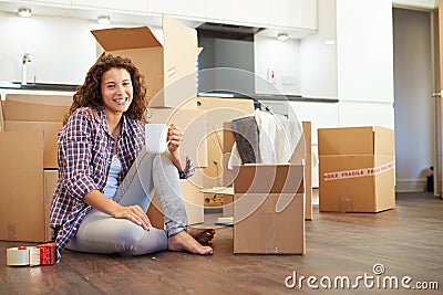 Woman Moving Into New Home And Unpacking Boxes