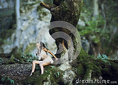 Woman near giant tree trunk in woods