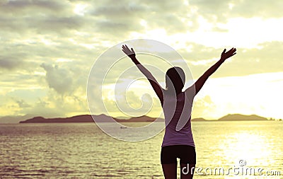 Woman open arms to sunrise