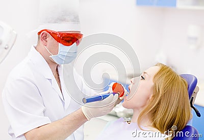 Woman with open mouth receiving dental filling drying proc