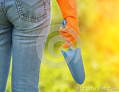 Woman in orange gloves working in the garden