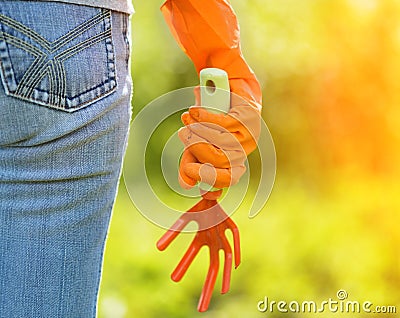 Woman in orange gloves working in the garden