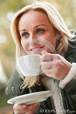 Woman In Outdoor Cafe With Hot Drink