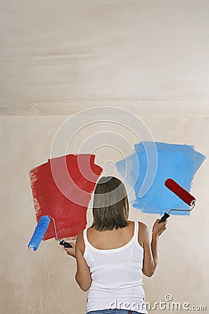 Woman Painting Wall Red And Blue With Paint Rollers
