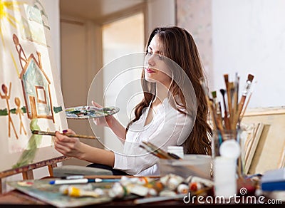Woman paints on canvas in workshop