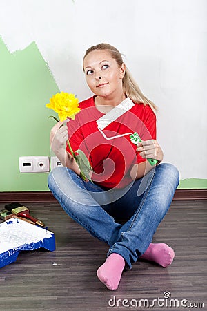 Woman paints interior wall of home
