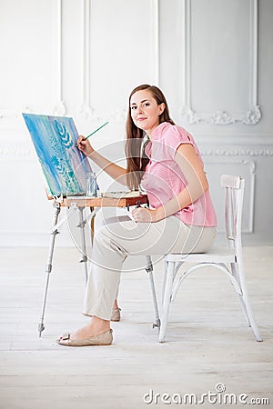 Woman paints picture on canvas