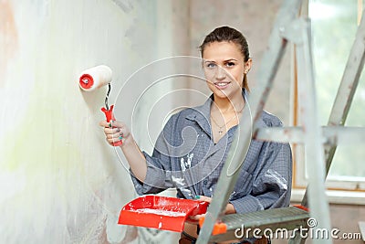 Woman paints wall at home