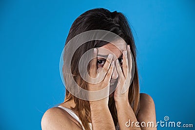 Woman peeking behind her hands