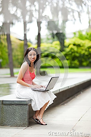 Woman on the phone and working on her laptop