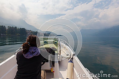 Woman piloting motor boat on a smooth, peaceful, beautiful